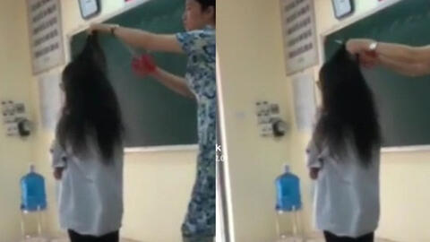 Cô giáo cầm kéo cắt tóc học sinh trên bục giảng