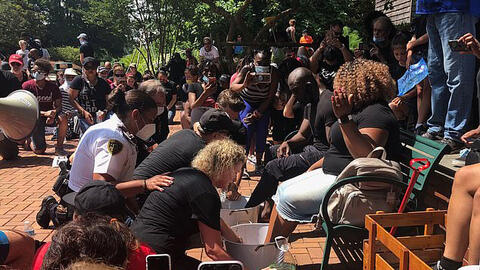 Cảnh sát cùng người dân tham gia lễ rửa chân cho các lãnh đạo tôn giáo da màu