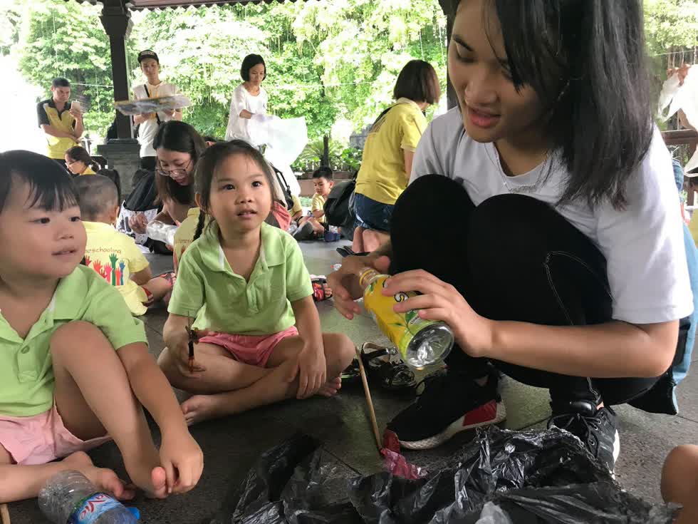 Các bạn CLB Les Pas Verts hướng dẫn các em nhỏ làm gạch từ rác. 