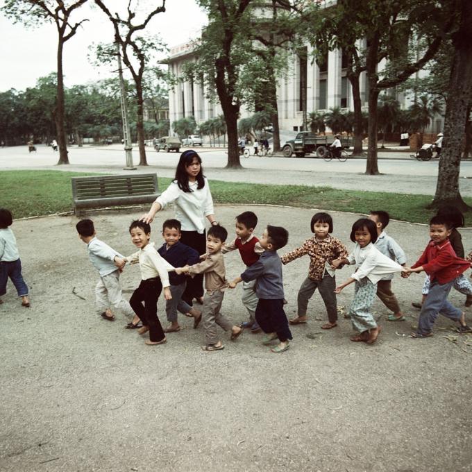 Cô giáo dẫn học sinh mẫu giáo tham quan vườn hoa Diên Hồng năm 1975. Vườn hoa nằm đối diện nhà khách Chính phủ, hai bên là Ngân hàng Nhà nước Việt Nam và khách sạn Metropole. Thời Pháp thuộc, vườn hoa có tên là quảng trường Chavassieux.