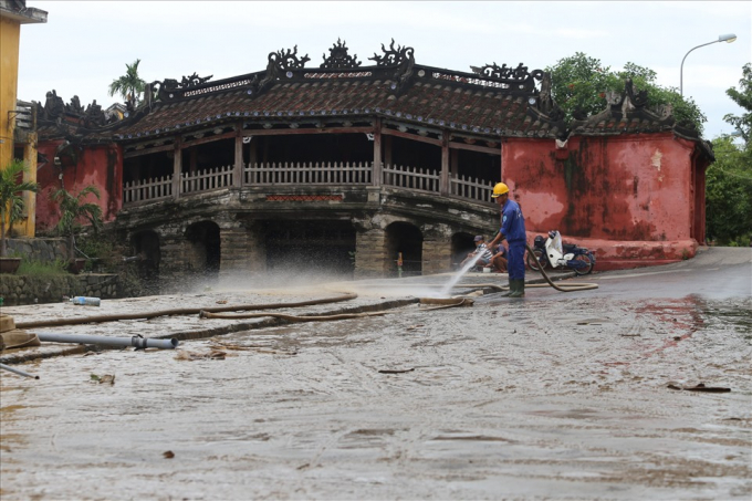  Công nhân dùng máy bơm rửa sạch lớp bùn non tại Chùa Cầu.