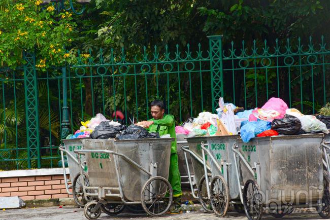 Công nhân thu gom phân loại rác làm việc giữ trưa nắng 12 giờ tại công viên Cầu Giấy.