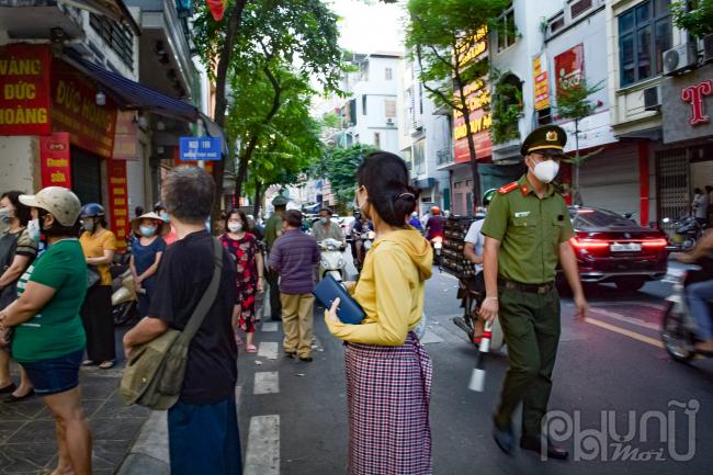 Mặc dù lực lượng chức năng có mặt để nhắc nhở thực hiện các quy định phòng, chống dịch nhưng rất đông người dân dừng lại mua bánh bên đường.