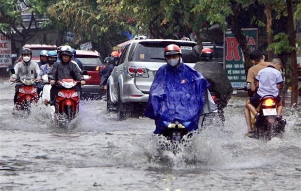 Mưa kéo dài khiến nhiều tuyến đường ngập cục bộ, gây khó khăn cho việc di chuyển của người dân. (Ảnh: Hồng Giang/TTXVN)