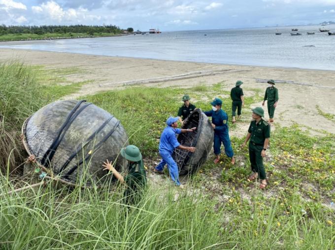 Bộ đội biên phòng thành phố Đà Nẵng cùng các lực lượng dân quân tự vệ  giúp bà con ngư dân đưa các thuyền thúng lên bờ trú bão.