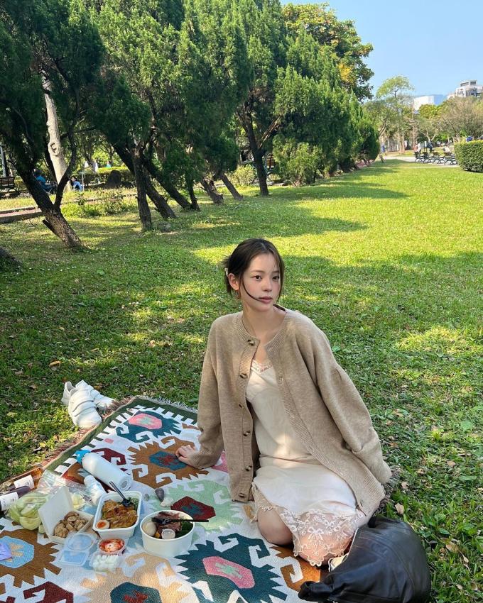   Khi đi picnic cùng bạn bè, Na Na chọn trang phục đơn giản và thoải mái nhưng vẫn giữ được nét dịu dàng vốn có. Cô nàng khéo léo phối chiếc váy liền 2 dây cùng áo len cardigan để ghi điểm duyên dáng cho diện mạo của mình. Sự kết hợp hài hòa tông màu nâu - be giúp outfit của Na Na càng trở nên đặc biệt và bắt mắt hơn.    