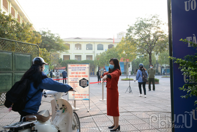 Giáo viên hướng dẫn học sinh thực hiện các quy định phòng chống dịch khi vào trường.