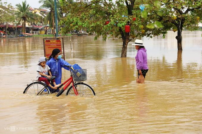 Người dân Hội An lội nước do đường phố bị ngập.