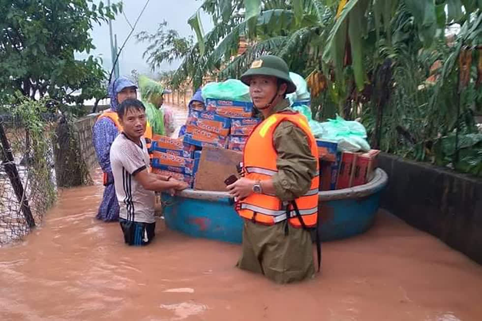 Ông Miên (phải) trong lúc cấp phát lương thực cho người dân vùng lũ.