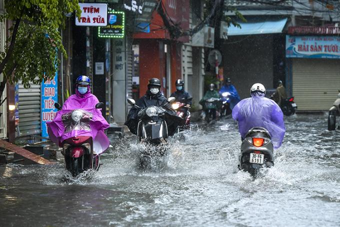 Các phương tiện đi qua vùng nước sâu tại phố Khương Hạ.