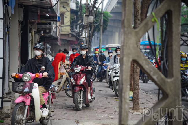 Người dân leo xe lên vỉa hè để di chuyển kịp giờ làm việc.