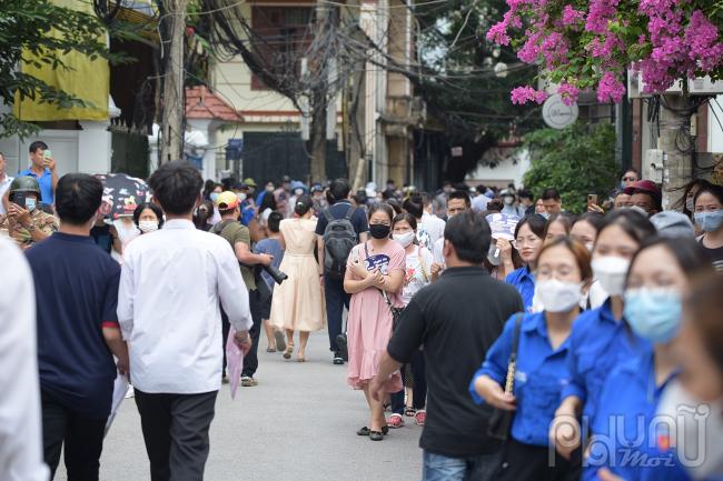 Ngoài cổng trường, hàng trăm phụ huynh chờ đợi mong ngóng con rời khỏi phòng thi.