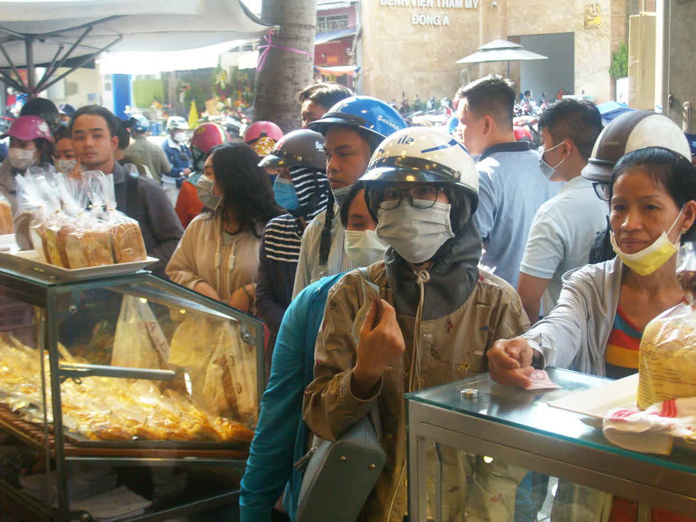 Ai ai cũng mong đến lượt mình cầm chiếc bánh mì thanh long với hương vị lạ lẫm, độc đáo trên thị trường. (Ảnh: Tri Thức)   