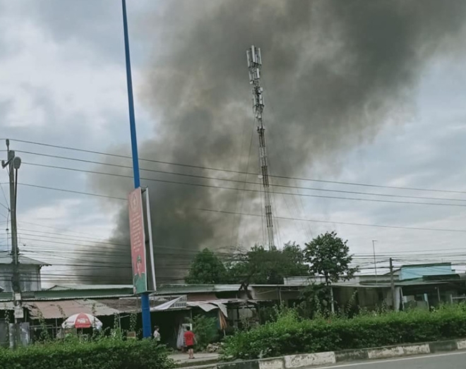 Từ xa nhìn thấy đám cháy bốc khói đen lên cao. 