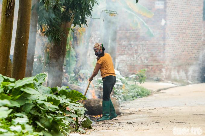 Một người dân đốt rác thải bên cạnh ngôi nhà có người bị nhiễm virus corona.