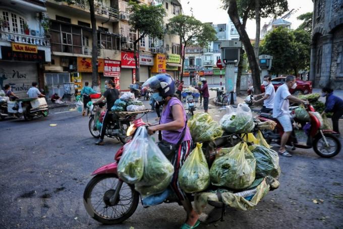 Tiểu thương và người đi chợ ngang nhiên tràn ra đường họp chợ như chưa hề có dịch bệnh, tại mặt đường Quán Thánh, khu vực bốt Hàng Đậu (ảnh chụp lúc 5h30 sáng 16/8). (Ảnh: Thành Đạt/TTXVN)