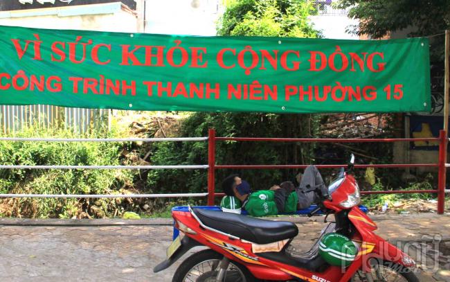 Lý do lớn nhất vẫn là mùi hôi từ dòng kênh bên cạnh. Trong ảnh là một tài xế xe công nghệ nghỉ trưa tại công viên, nhưng vẫn phải đeo khẩu trang.