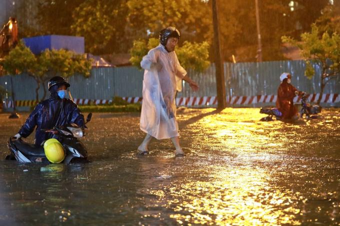 Dòng xe di chuyển chậm chạp hoặc phải dắt xe mò đường, người đi bộ phải đi sát vào nhà dân hoặc đi trên dải phân cách.