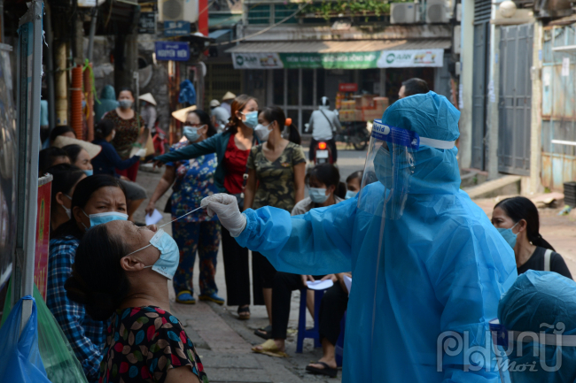 Nhân viên y tế phường Bách Khoa tiến hành lấy mẫu xét nghiệm Covid cho các tiểu thương.