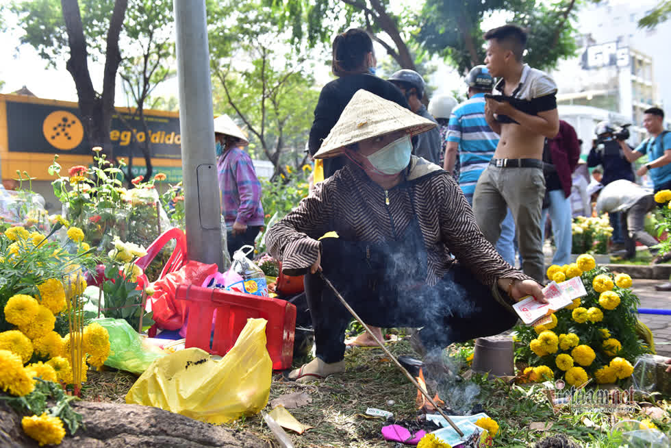 Một tiểu thương đốt vàng mã xả xui khi hoa bán không hết.