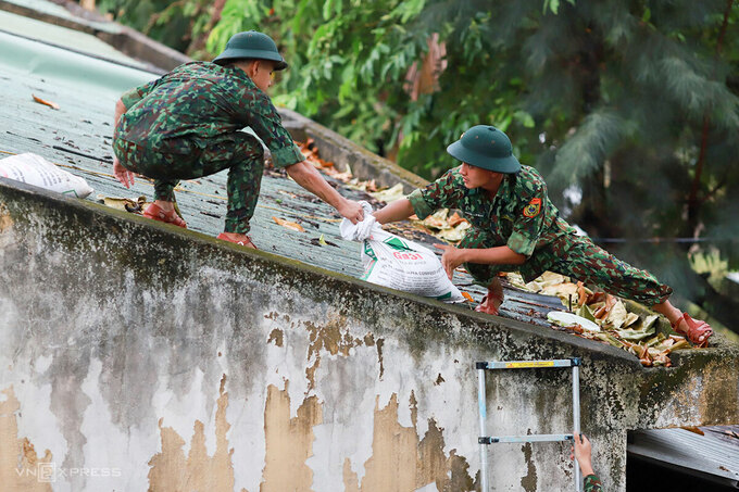   Chiến sĩ Đồn Biên phòng Phú Lộc giúp dân chằng chống lại nhà cửa. Ảnh: Nguyễn Đông.  