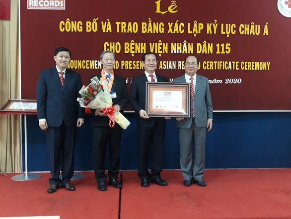   Bác sĩ Phan Văn Báu - giám đốc Bệnh viện Nhân dân 115 (thứ 2 phải qua) và bác sĩ Chu Tấn Sĩ (thứ 3 phải qua) nhận chứng nhận kỷ lục từ Tổ chức kỷ lục Việt Nam - Ảnh: HOÀNG LỘC  