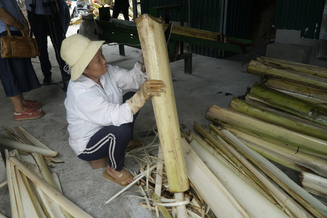 Công nhân bóc tách bẹ chuối trước khi đưa vào máy chẻ, ép thành sợi.