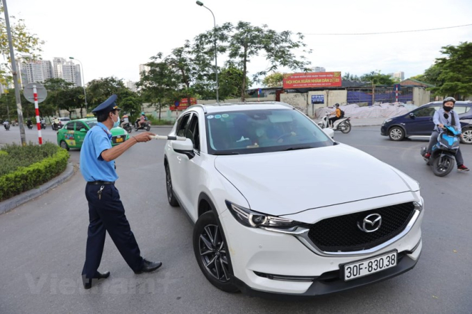 Lực lượng chức năng tại nút giao này hướng dẫn phương tiện di chuyển theo lộ trình khác và tuyên truyền về thay đổi phân luồng. (Ảnh: Hoài Nam/Vietnam+)