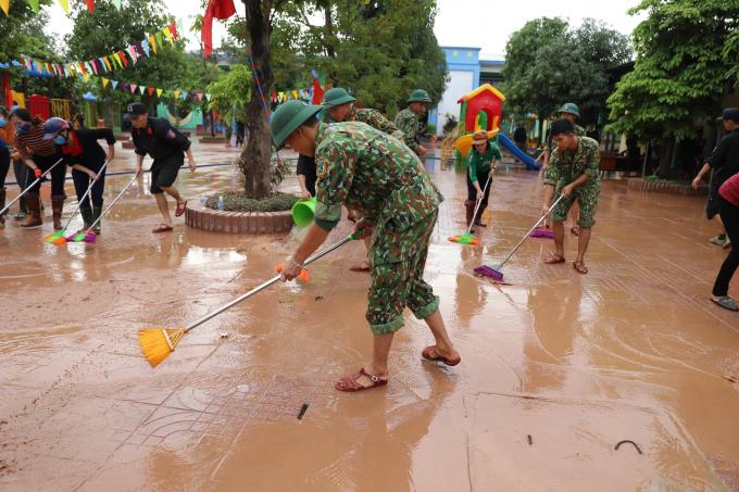 Các chiến sĩ công an, bộ đội và giáo viên được huy động đến trường  Mầm non Cẩm Mỹ dọn dẹp sau lũ.