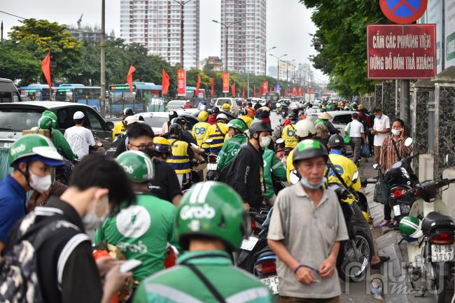 Bên ngoài khu vực đỗ xe của bến Giáp Bát, hành khách đi xe ôm công nghệ kéo nhau về bến ùn tắc chật cứng.