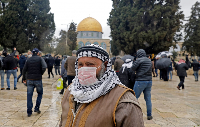 Một người đàn ông Palestine đeo khẩu trang bảo hộ, đứng trước đền thờ Mái vòm Dome of Rock bên trong nhà thờ Hồi giáo Al-Aqsa tại thành phố cổ Jerusalem (Ảnh: Ahmad Gharabli/AFP/Getty Images).