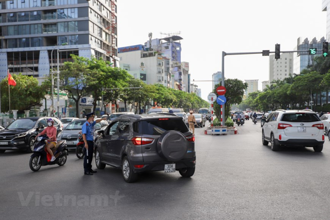 Một phương tiện giao thông cố tình rẽ trái được lực lượng chức năng nhắc nhở di chuyển đúng phần đường quy định. (Ảnh: Minh Sơn/Vietnam+)