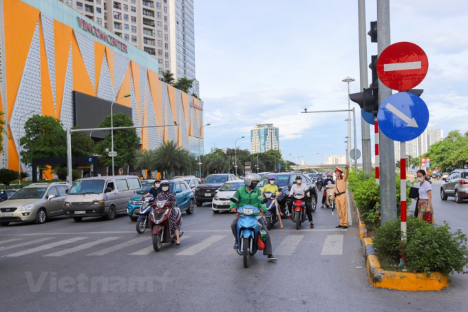 Lực lượng chức năng phải nhắc nhở và hướng dẫn người dân tham gia giao thông đúng luật. (Ảnh: Minh Sơn/Vietnam+)