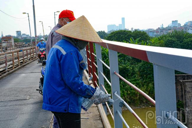 Lan can sẽ được đánh gỉ sạch bằng máy chà sau đó sơn chống gỉ rồi tiếp theo sơn lớp phủ. Lan can cầu có rất nhiều chi tiết nhỏ nên các công nhân đang thực hiện nhiệm vụ tại đây đều rất tỉ mỉ khi sơn lại thành cầu.