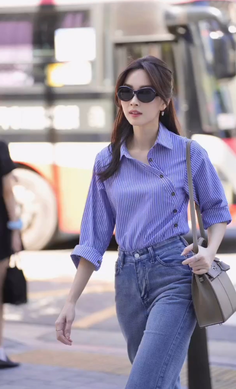               Cô phối áo sơ mi kẻ sọc cùng quần jeans và không quên mix thêm túi xách, mắt kính.         