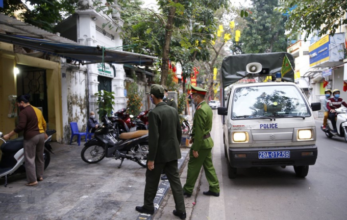 Lực lượng công an phường Hãng Mã ra quân đề nghị các hộ kinh doanh đóng cửa quán ăn đường phố, trà đá, cà phê. Ảnh: Doãn Tuấn/TTXVN