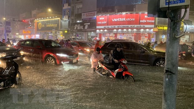 Nhiều tuyến đường chính của Đà Nẵng ngập sâu, người dân di chuyển khó khăn. (Ảnh: Văn Dũng/TTXVN)