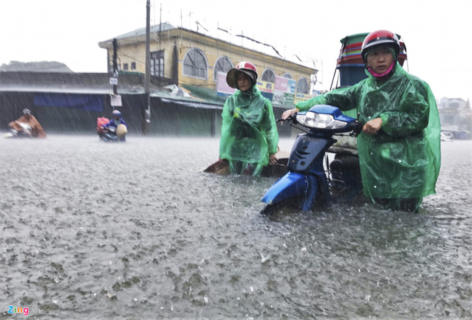 Nhiều phương tiện giao thông đi qua những đường này bị chết máy. Công an Nghệ An đã túc trực tại các điểm ngập để hỗ trợ người tham gia giao thông. (Ảnh: Zing).