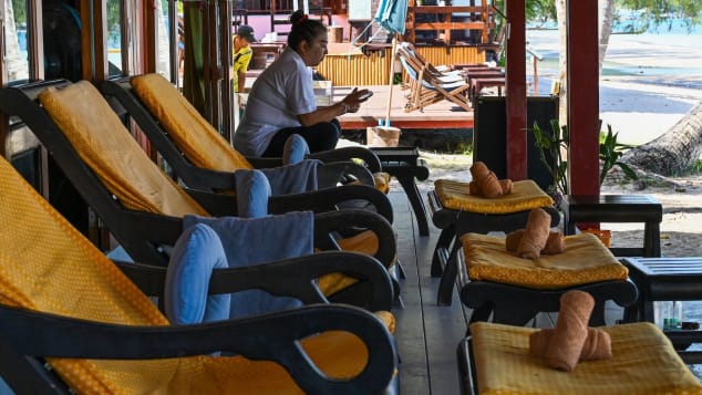 Nhân viên mát xa ngồi chơi vì không có khách trên đảo Koh Tao, Thái Lan. Ảnh: AFP.