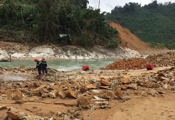   Lực lượng cứu hộ sử dụng máy bơm xịt lớp đất đá để tìm các nạn nhân. Ảnh: Đình Hồng.  