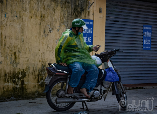 Xe ôm công nghệ phải khoác thêm áo mưa bên ngoài để chắn gió do phải di chuyển liên tục.