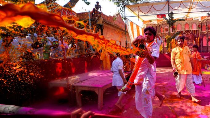 Tại Mathura, Ấn Độ, người theo đạo vui đùa cùng bột và nước trong lễ hội. Holi thường là dịp thu hút khá nhiều khách du lịch (Ảnh: Avishek Das/SOPA Images/Shutterstock).