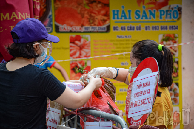 Thực phẩm được các tiểu thương trong chợ mang ra tận khu vực rào chắn phục vụ.