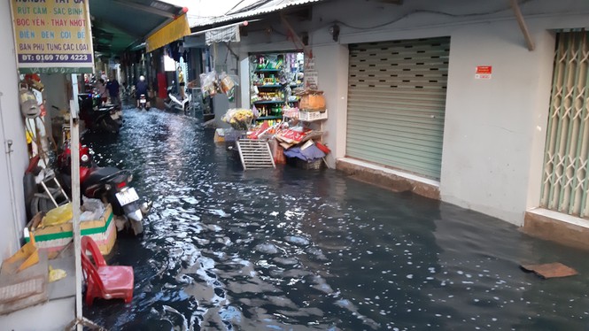 Nước từ ngoài đường tràn vào nhà dân khiến cuộc sống sinh hoạt, buôn bán gặp nhiều khó khăn. Ảnh: báo Tiền Phong