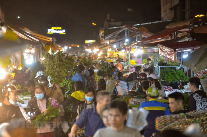   Đêm trước ngày 8/3, chợ hoa Quảng An (Hà Nội) lại càng nhộn nhịp, tấp nập cảnh kẻ bán người mua. (Ảnh: Minh Sơn/Vietnam+)  