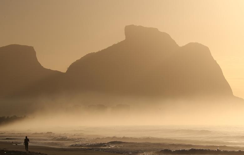 Một người phụ nữ đi dạo trên bãi biển Recreio dos Bandeirantes ở Rio de Janeiro, Brazil ngày 25/3.