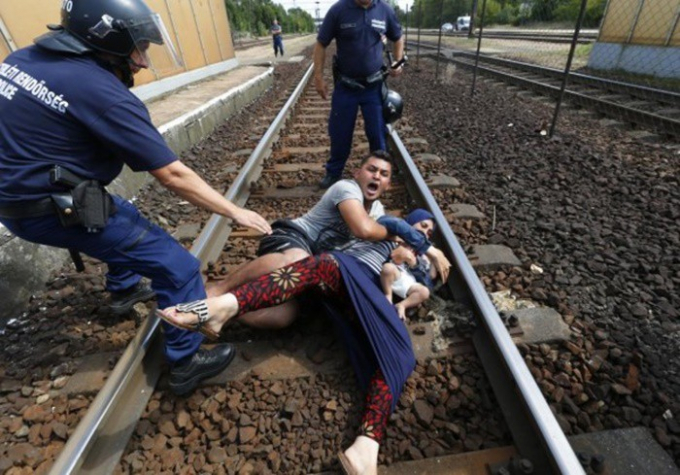 Cảnh sát ngăn cản một gia đình di cư bỏ chạy tại nhà ga ở thị trấn Bicske, Hungary.