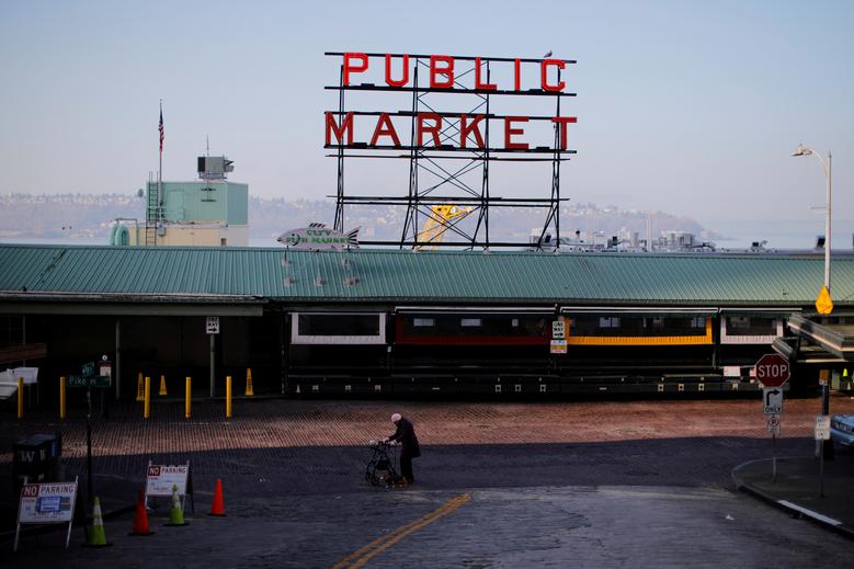 Một người phụ nữ đi bộ qua những con đường vắng bên ngoài Chợ Pike Place ở Seattle, Washington.