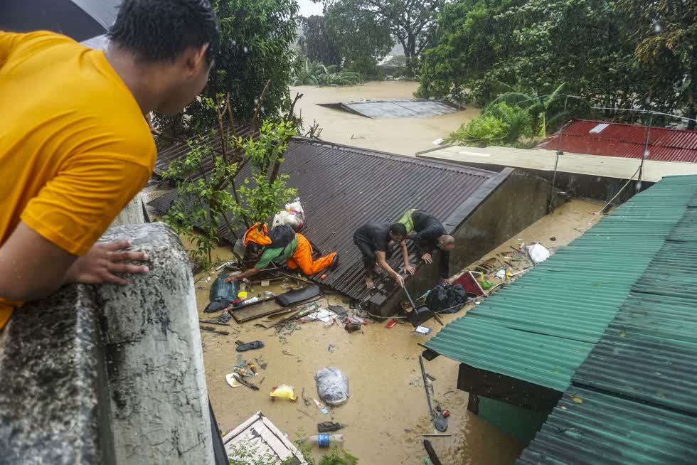 Người dân tại khu vực San Mateo đứng trên mái nhà để vớt tài sản. Ảnh: Getty Images