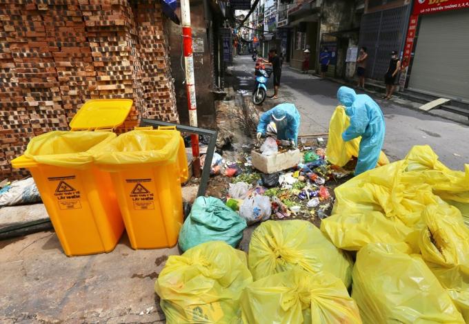 Công nhân môi trường ở các khu phong tỏa luôn làm việc trong môi trường độc hại, có nguy cơ lây nhiễm COVID-19. (Ảnh: Hoàng Hiếu/TTXVN)